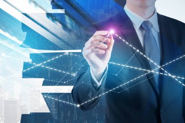 Tanınmayan işadamı grafik cityscape arka plan üzerinde ayakta parlayan kalemiyle çizim. Çift tonlu görüntü pozlaması