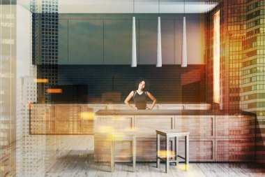 İç beyaz ve siyah tuğla duvarlar, ahşap zemin, gri ve ahşap mutfak tezgahı ile modern mutfak ve gri ve ahşap bar tabureleri ile kadın. Çift tonlu görüntü pozlaması