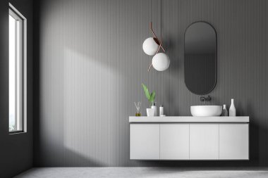 Gri duvarlar, taş zemine, gri tezgah üzerinde beyaz lavabo duran ve üstündeki dar ayna idam ile modern banyo iç. 3D render