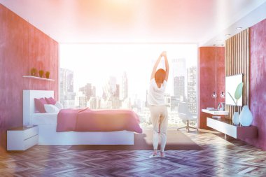 Kırmızı duvarlar, ahşap zemin, panoramik penceresi, kırmızı ana yatak ve ev ofis köşe büyük tv ile yatak odası iç yan görünüm ayarlayın. Kadın pijama. Tonlu görüntü