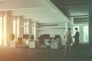 İşadamları beyaz duvarları, çatı windows, gri halı ve sandalye ile beyaz bilgisayar tabloları satırları ile modern açık alan ofis köşesinde. Dolap duvarın yanında satır. Çift tonlu görüntü pozlaması