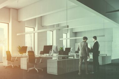 Açık alan office gri halı zemin ve gri sandalye ile beyaz bilgisayar tabloları satırları üzerinde beyaz duvarlı, çatı windows, yan görünüm. Dolap satır. İş adamları. Çift tonlu görüntü pozlaması
