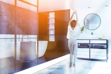 Kadın köşesindeki lüks banyo beyaz mermer duvarlar ve zemin, küvet ve lavabo beyaz tezgah üzerinde duran gri havlu ile beyaz. Tonlu görüntü