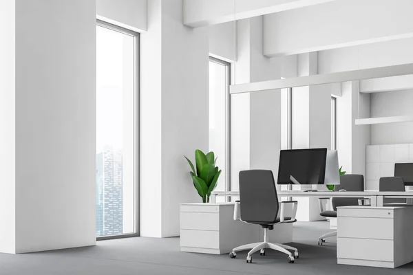 白色办公室的角落 有白色的墙壁 狭窄的窗户 白色的电脑桌子与台式机和灰色的椅子和储物柜附近的墙壁 — 图库照片