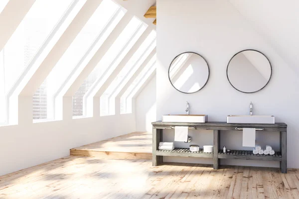 Attic bathroom interior with white walls, wooden floor and white double sink standing on gray countertop with round mirrors above it. 3d rendering