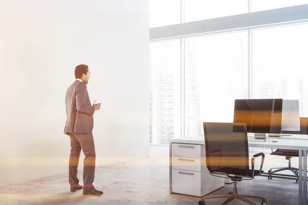商人站在现代办公场所 白色的墙壁 混凝土地板和白色的电脑桌子与黑色的椅子 色调的图像 — 图库照片