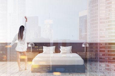 Beyaz ve gri duvarlar, ahşap zemin, beyaz kapaklı gri ana yatak ve iki ahşap başucu masa lambaları ile minimalist yatak odası iç kadında. Çift tonlu görüntü pozlaması