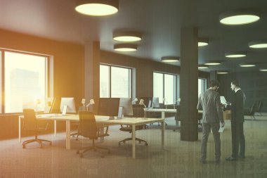 Endüstriyel stil office kahverengi duvarlı köşesinde erkeklerde halı zemin, sütunlar ve kahverengi sandalye ile beyaz bilgisayar tabloları satırları. Lounge alanı içinde belgili tanımlık geçmiş. Çift tonlu görüntü pozlaması
