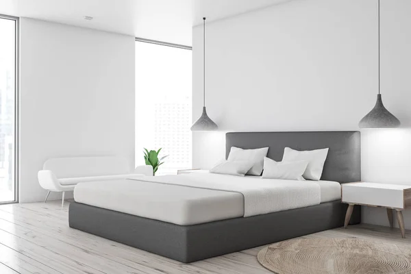 主卧室角落有白色的墙壁 木地板 灰色的主床与白色的封面 白色床头柜和白色沙发 — 图库照片