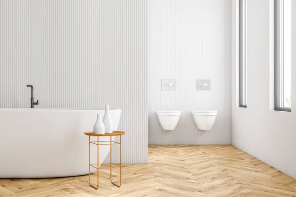 Interior of modern bathroom with white walls, wooden floor, loft windows, white bathtub and two toilets. 3d rendering