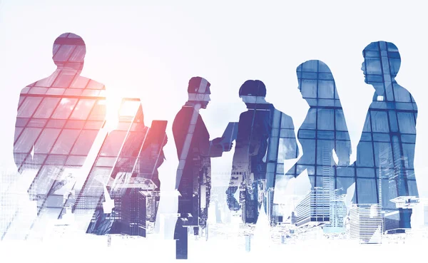 Silhouettes of business team members over white background with double exposure of skyscraper and upside down cityscape. Teamwork concept. Toned image