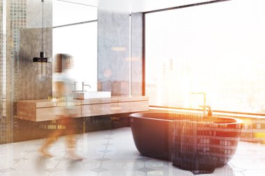 Beton duvarlar, modern banyo iç kadında döşeli zemin, panoramik pencere, gri küvet ve beyaz Lavabonun üstündeki dikey ayna ile. Çift tonlu görüntü pozlaması bulanıklık