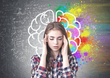 Kareli gömlek giymiş ve renkli beyin kroki ile blackboard oturan bir baş ağrısı olan stresli genç kadın portresi.