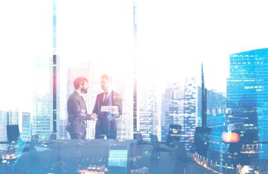 Toplantı salonu panoramik ofiste el sıkışan iki genç işadamları. Cityscape çift pozlama. Tonlu görüntü