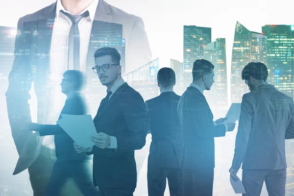 Unrecognizable business leader and members of his team standing over white background with double exposure of cityscape. Leadership concept. Toned image double exposure