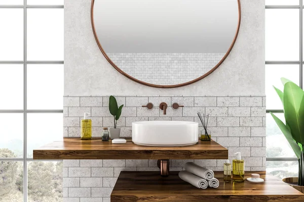 白色圆形浴室水槽站在木制架子上 上面有圆形镜子 房间里有白色和砖墙以及大窗户 — 图库照片