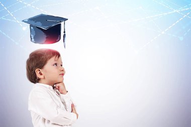 Beyaz gömlek düşünme ayakta mezuniyet şapka ve başını çizilen grafikleri ile beyaz duvarının yakınında sevimli küçük çocuk yan görünüm. Yukarı alay