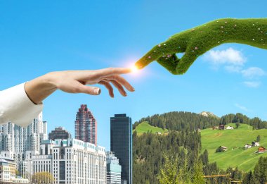 Kadın el çim el ile modern cityscape ve onları altında kırsal manzara çiçeklerle çok dokunaklı. Şehir yeşil tutulması kavramı. Tonlu görüntü