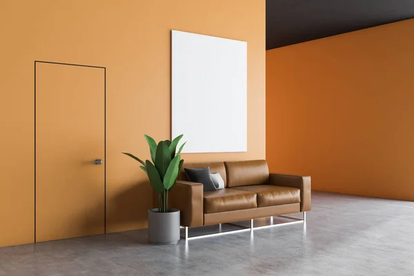 Office waiting room interior with orange walls, concrete floor, leather sofa with cushions and vertical poster hanging above it. 3d rendering mock up