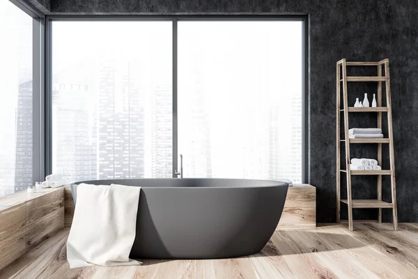 Interior of panoramic bathroom with gray walls, wooden floor, gray bathtub with a towel on it and wooden shelves with towels and creams. 3d rendering