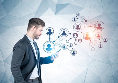 Genç işadamı ile sosyal medya kroki üzerine geometrik desen duvarının yakınında onun smartphone ayakta bakarak yan görünüm sakallı