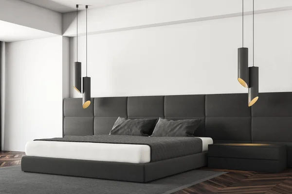 Corner of minimalistic bedroom with white walls, dark wooden floor, gray master bed standing on gray carpet, black bedside tables and stylish lamps. 3d rendering