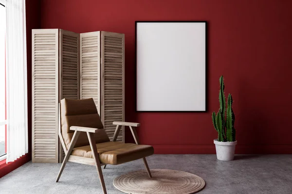 Interior of minimalistic living room with red walls, concrete floor, a beige leather armchair and vertical poster hanging on the wall. Wooden screen near the window. 3d rendering mock up