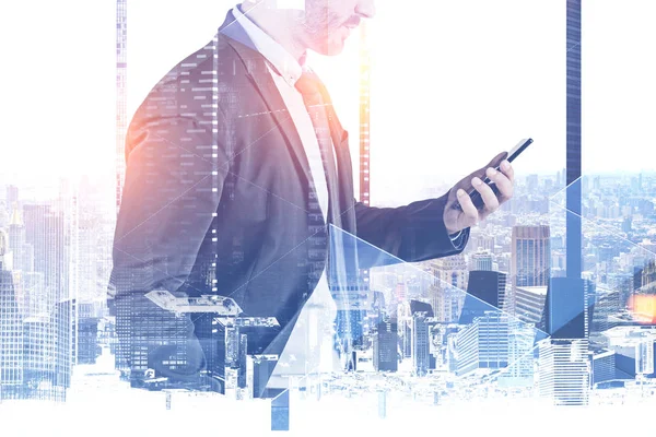 Side view of unrecognizable businessman looking at smartphone in panoramic office with double exposure of cityscape. Toned image