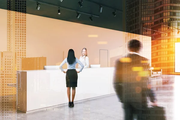 Business people near white reception desk standing in modern office with orange walls, concrete floor, two doors and a leather sofa. Toned image double exposure