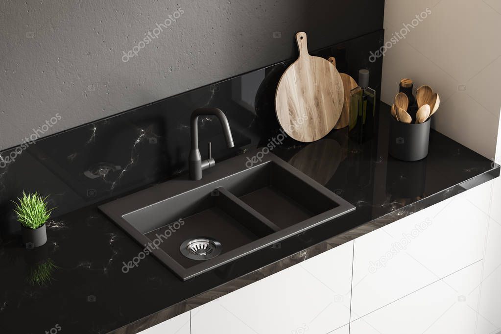 Top view of black marble kitchen sink standing on white countertop in room with black walls. Wooden round cutting board and little potted plant. 3d rendering