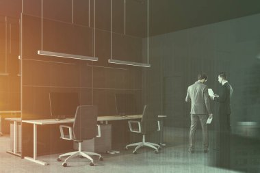 İşadamları gri ve cam duvarlar, beton zemin ve gri sandalye ile birkaç beyaz ve gri Bilgisayar masaları ile modern ofis köşesinde onlara yakın. Çift tonlu görüntü pozlaması