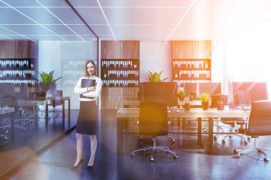 Beyaz duvarları, siyah zemin, siyah sandalye ve klasörlerle ahşap kitaplıklar ile ahşap Bilgisayar masaları ile panoramik ofis iç iş kadını. Tonlu görüntü