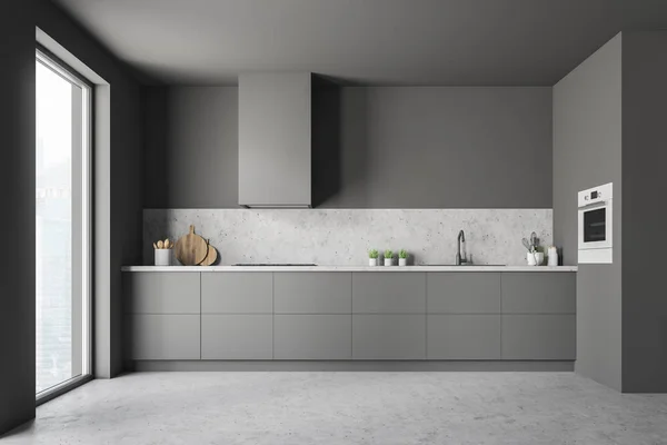 Minimalistic kitchen interior with gray walls, concrete floor, loft window and gray and stone countertops with built in sink and cooker. 3d rendering