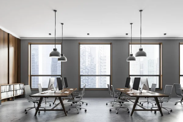 灰色と暗い木製の壁 ロフト窓 コンクリートの床 暗い木製のコンピューターのテーブルの行とオープン スペースのオフィスの側面図です レンダリング — ストック写真