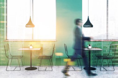 Minimalist kafe iç yeşil duvarlar, petek desen kat, büyük pencereler ve metal sandalyeler ve özgün tavan lambaları ile küçük kare tablo ile bir adam. Çift tonlu görüntü pozlaması bulanıklık