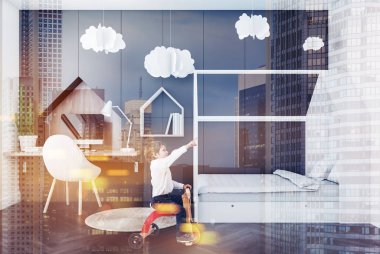 Gri duvarlar, koyu ahşap zemin, şık beyaz yatak ve bilgisayar tablo beyaz sandalye ile çocuk yatak odası iç içindeki küçük çocuk. Kağıt bulutlar. Çift tonlu görüntü pozlaması