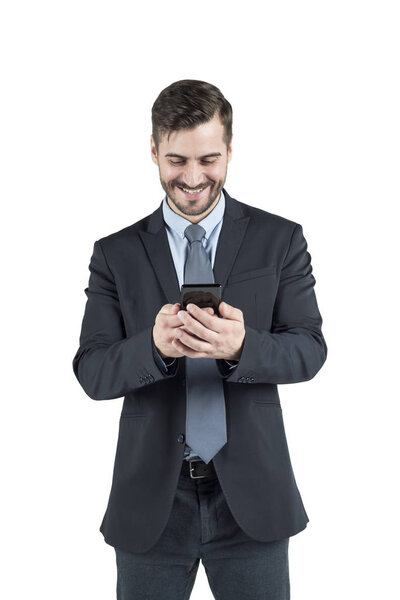 Изолированный портрет улыбающегося бородатого бизнесмена в костюме, смотрящего на экран своего смартфона. Концепция хороших новостей
.