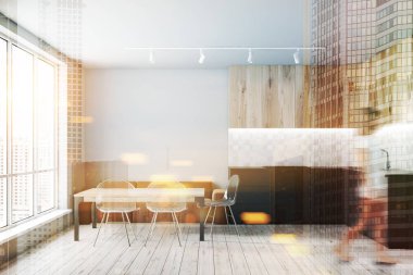 Kadın iç kahverengi kanepe ve şeffaf sandalyeler ile ahşap masa ve beyaz duvarlar, ahşap zemin, gri mutfak tezgahı ve ahşap dolapları ile modern mutfak. Çift tonlu görüntü pozlaması bulanıklık