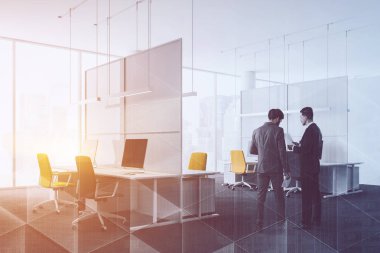 İşadamları beyaz duvarlar, halı kaplı zemin, cityscape, sütunları ile satırları gri ve sarı sandalye ile Bilgisayar masaları ile panoramik pencerelere ile modern ofis köşesinde. Çift tonlu görüntü pozlaması