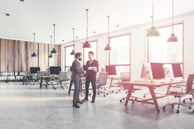 Açık alan Office beyaz ve açık ahşap duvar, çatı windows, beton zemin ve hafif ahşap bilgisayar tabloları satırları iç iş adamları. Tonlu görüntü