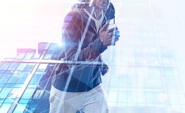 Tanınmayan genç Afro-Amerikan jogger akıllı telefon ve kulaklık ile gökdelen arka plan üzerinde çalışan portresi. Çift tonlu görüntü pozlaması