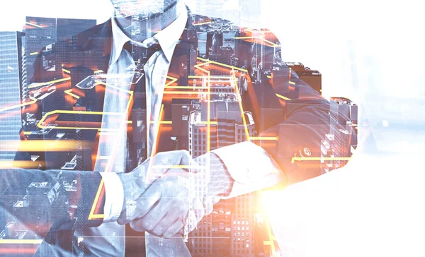 Parlayan kent planı ile cityscape arka plan üzerinde el sıkışan iki tanınmaz işadamlarından kapatın. Çift tonlu görüntü pozlaması