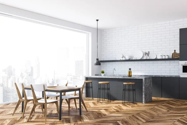 Corner of kitchen with white brick walls, wooden floor, panoramic window, gray and marble countertops and bar with stools. Wooden table with chairs. 3d rendering