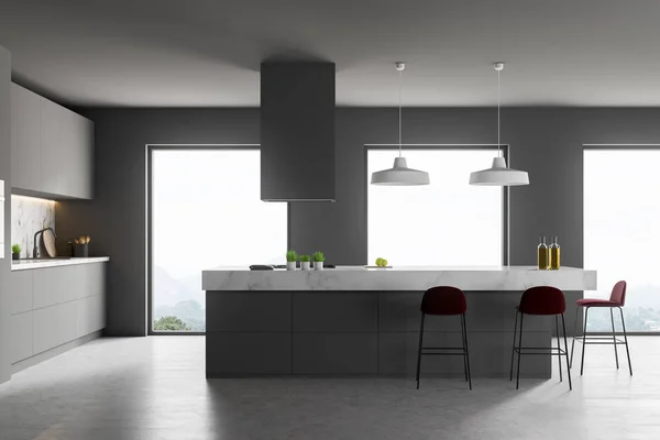 Interior of stylish kitchen with gray walls, concrete floor, loft windows, gray countertops and cupboards and white and gray island with stools. 3d rendering