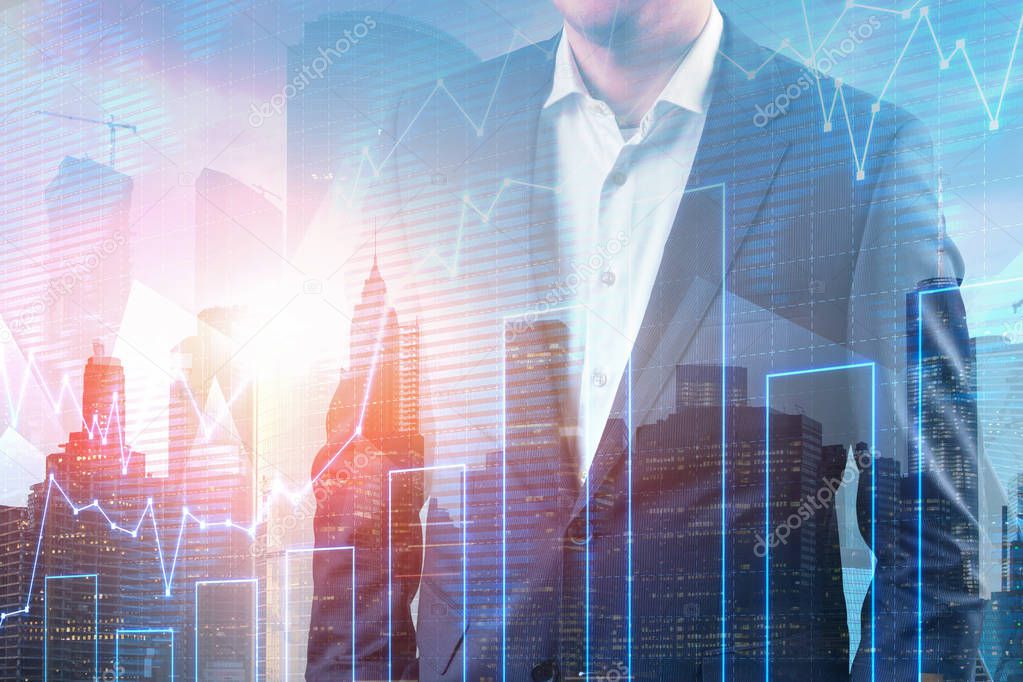 Unrecognizable businessman in dark suit and white shirt standing over cityscape background. Double exposure of graph. Toned image. Stock market concept