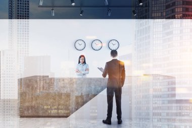 Beyaz ve beton resepsiyon masası nın yakınındaki iş adamları, duvarda beyaz duvarlar, beton zemin ve saatler ile modern ofiste duruyor. Tonlu görüntü çift pozlama