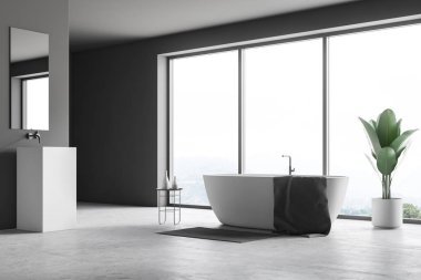 Gri duvarlar, beton zemin, pencere ve beyaz kare Lavabonun üstündeki dikey ayna ile yakınındaki bir havlu ayakta beyaz banyo küvetinde panoramik banyo iç. 3D render