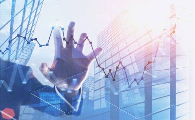 Hand of unrecognizable businessman working with interactive graph in city. Concept of trading and hi tech. Toned image double exposure