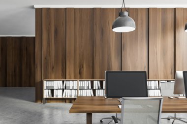 Close up of office workplace with dark wooden walls, concrete floor and dark wooden computer tables. Shelves with folders near the wall. 3d rendering