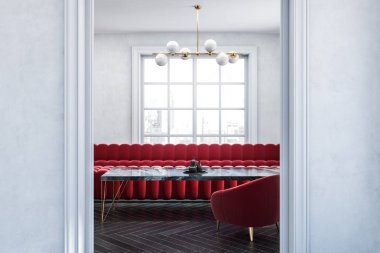 Geniş kapıdan görülen siyah mermer masanın yanında duran kırmızı kanepe ve koltuklar ile boş beyaz oda iç kapatın. 3d render